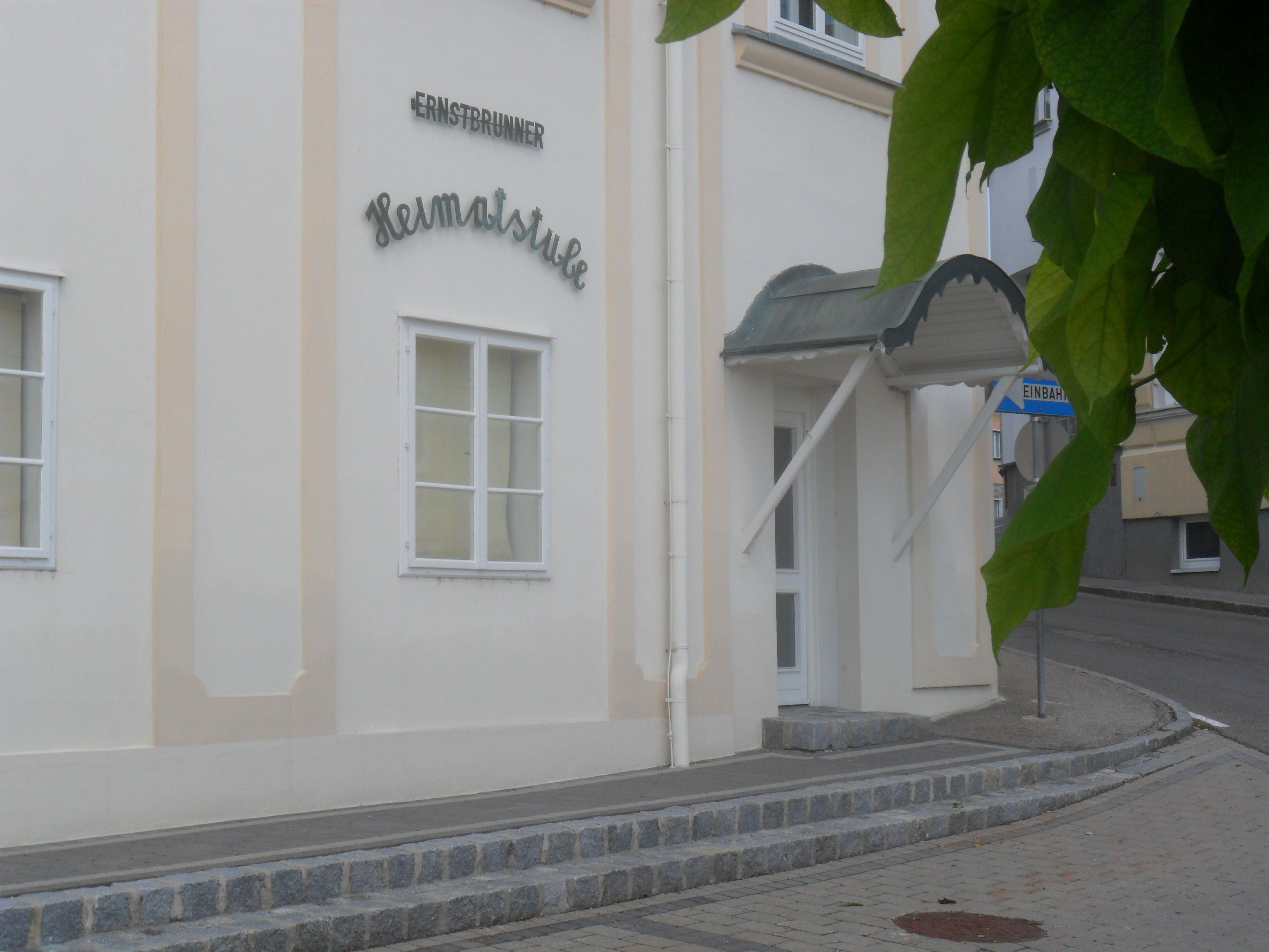 Az Ernstbrunn helytörténeti szalon bejárata előtetővel és utcatáblával.