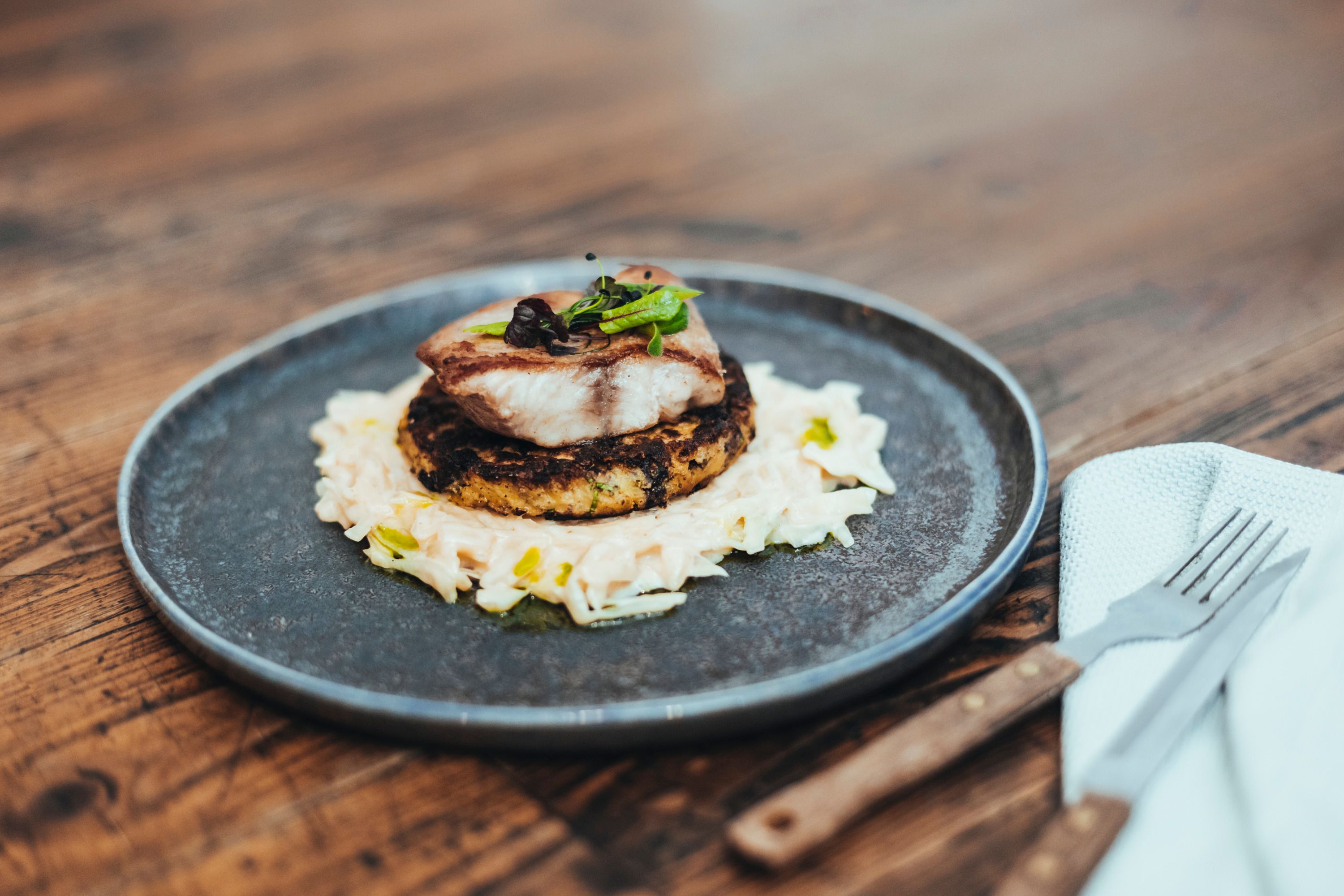 Egy tál halat rösti és káposzta tányéron.