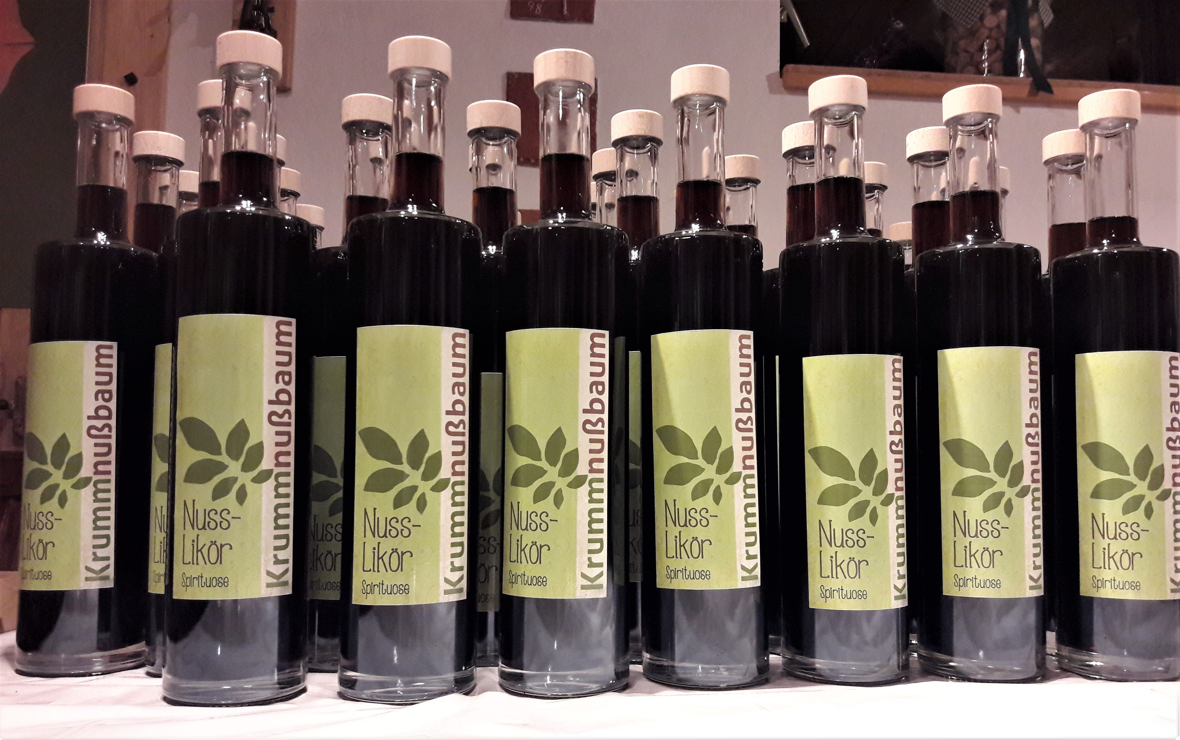 Diólikőrös üvegek sora, zöld címkékkel.