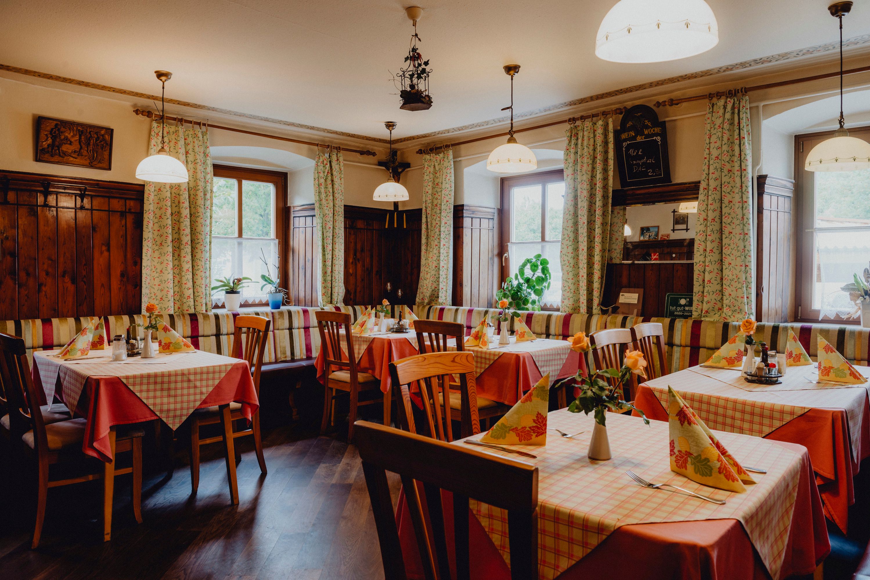 Hangulatos vendéglő fabútorokkal és kockás terítőkkel.