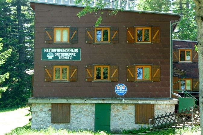 Háromszintes épület, fa nyílászárókkal és a Naturfreunde Ternitz felirattal.