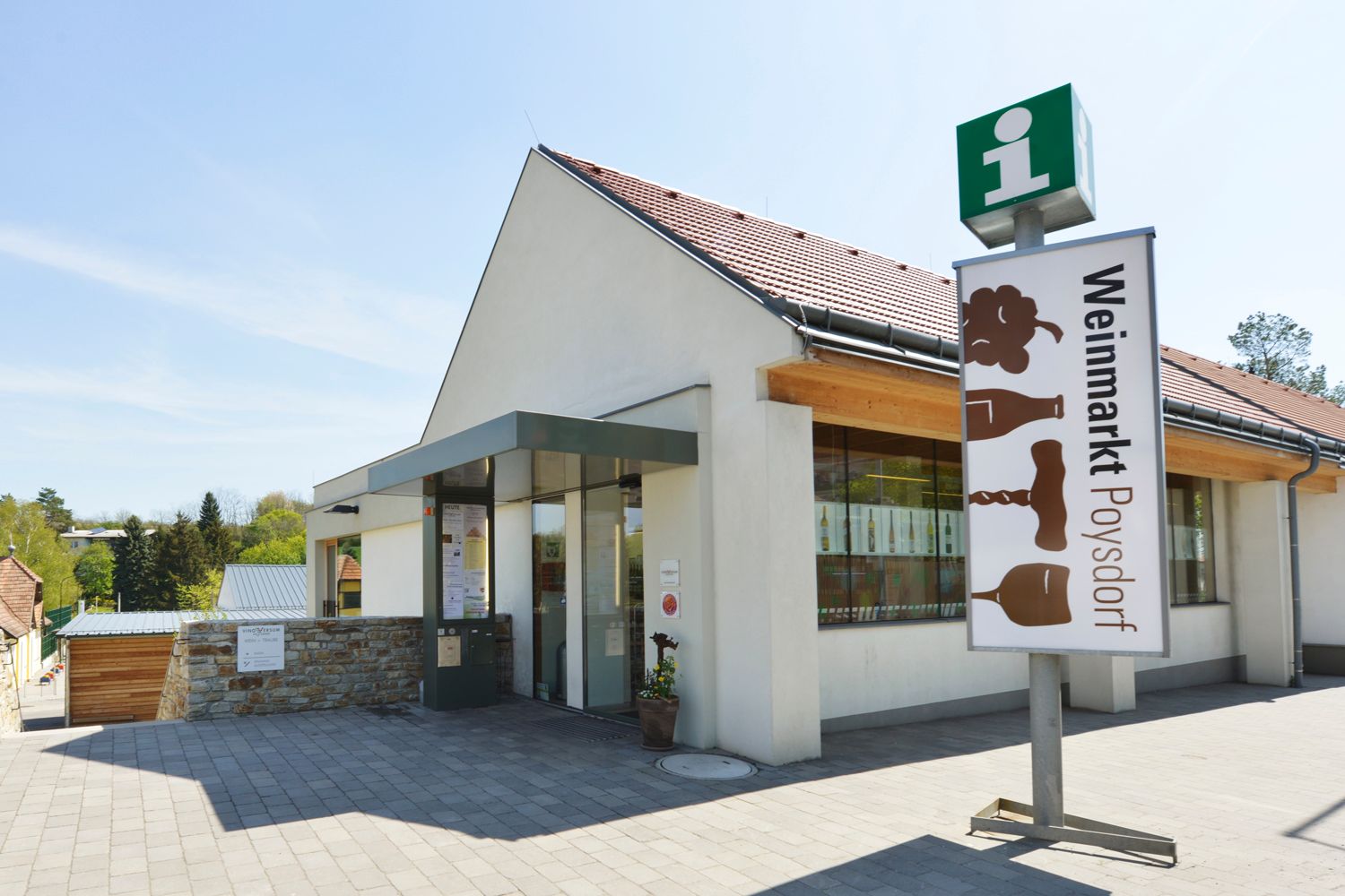 A poysdorfi borpiac bejárata táblával és üveghomlokzattal.