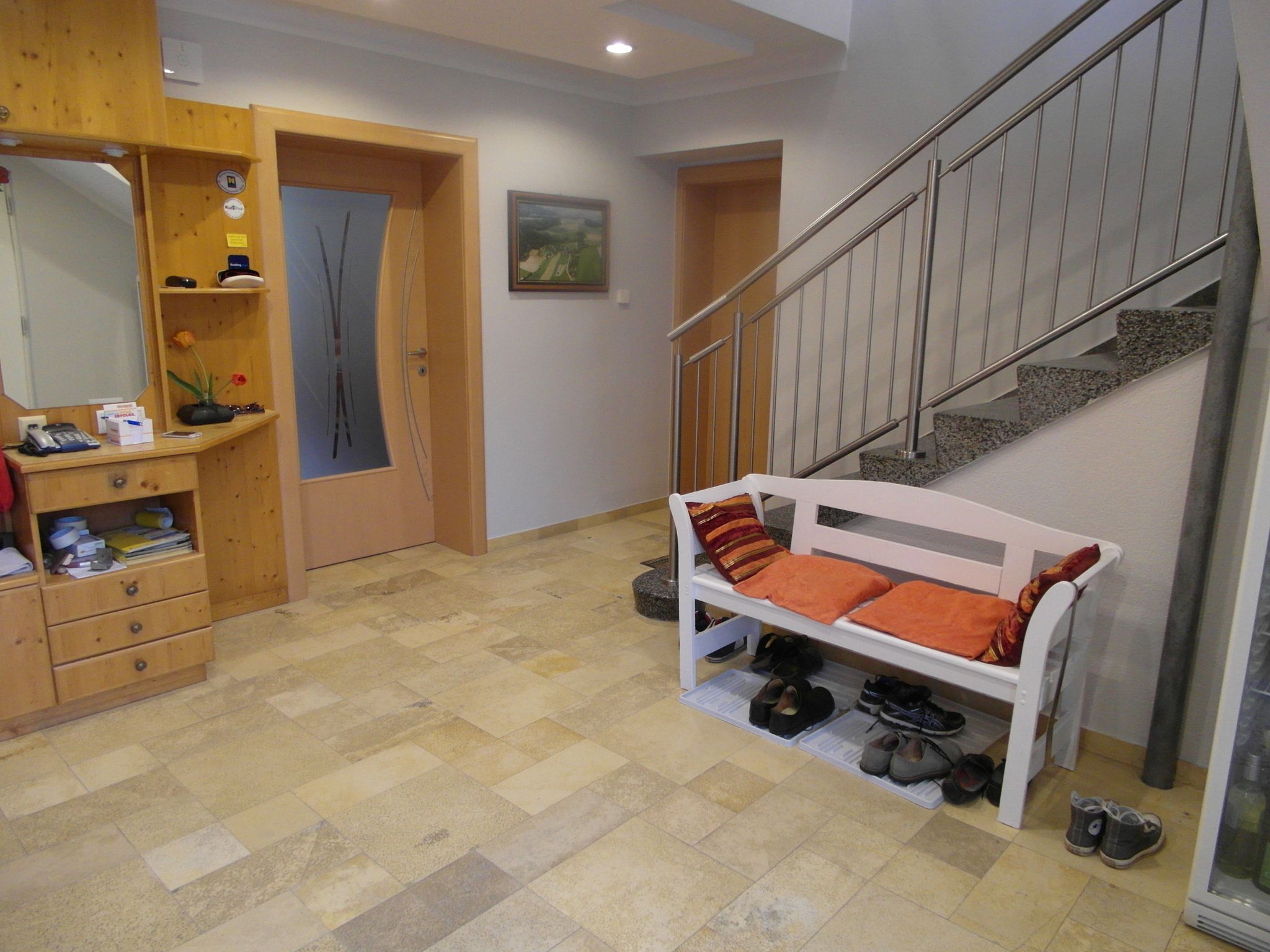 Bejárati rész fából készült komóddal, párnázott paddal és lépcsővel.