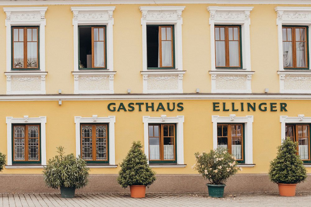 Egy sárga színű vendéglő homlokzata "Gasthaus Ellinger" felirattal.