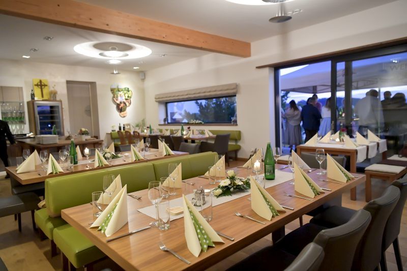 Elegáns kóstolóterem terített asztalokkal és dekorációval.