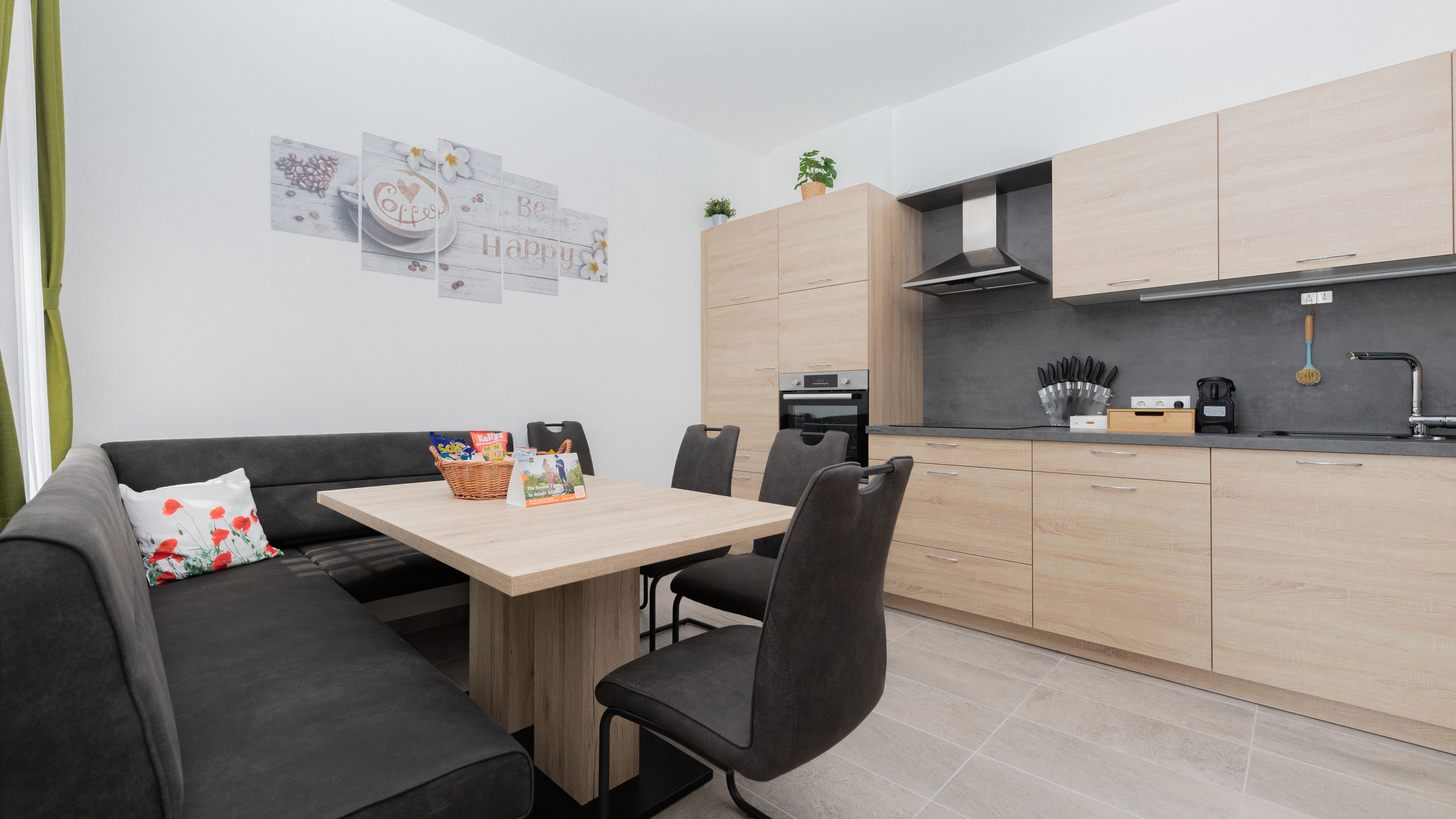 Modern konyha fa bútorokkal, étkezőasztallal, sarokpaddal és székekkel.