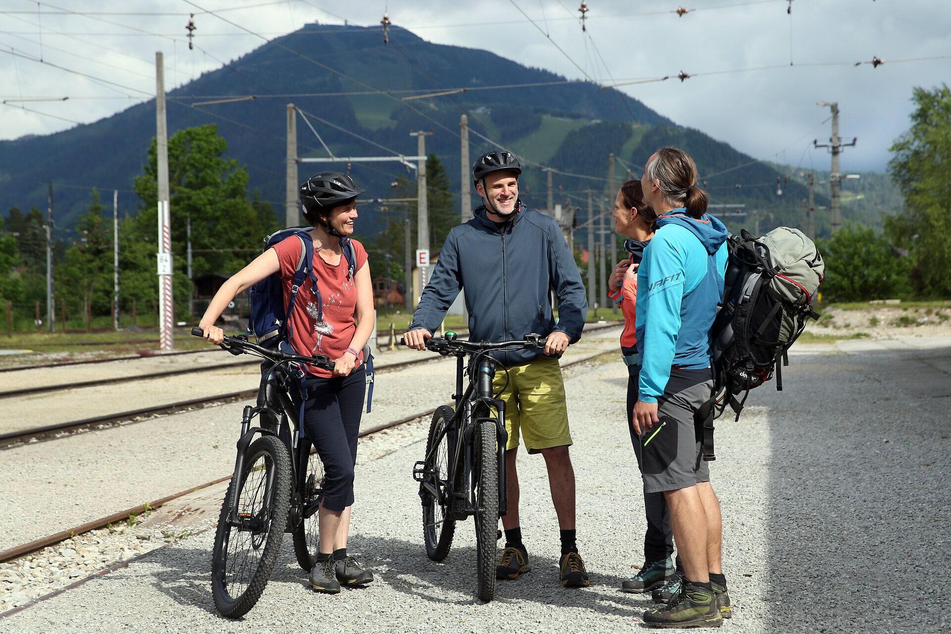 Eine Gruppe von Radfahrern genießt die frische Bergluft und die atemberaubende Landschaft. Umgeben von sanften Hügeln und üppigem Grün, strahlt die Szenerie eine einladende Atmosphäre aus, die zum Entdecken einlädt.