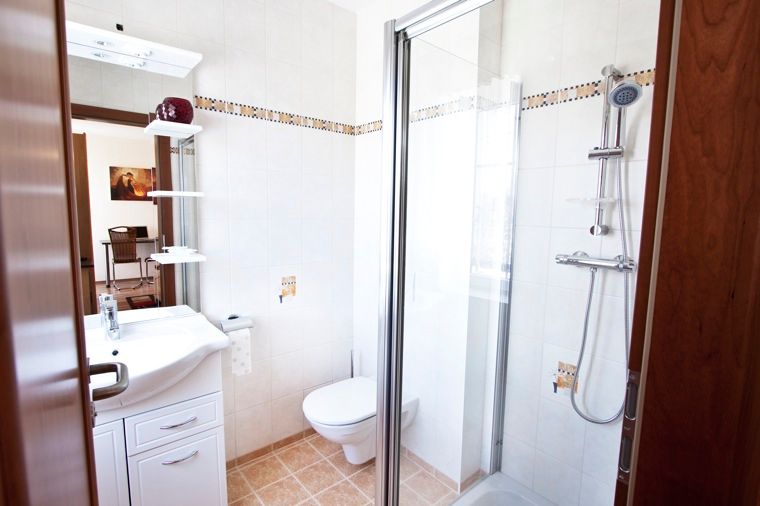 Modern fürdőszoba zuhanyzóval, mosdóval és WC-vel.