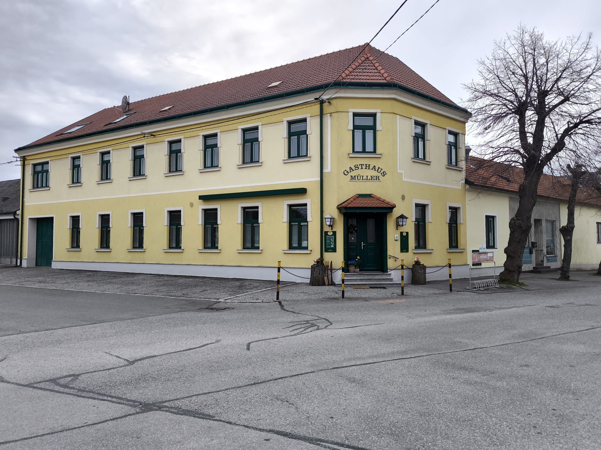 Sárga kétszintes épület "Gasthaus Müller" felirattal.