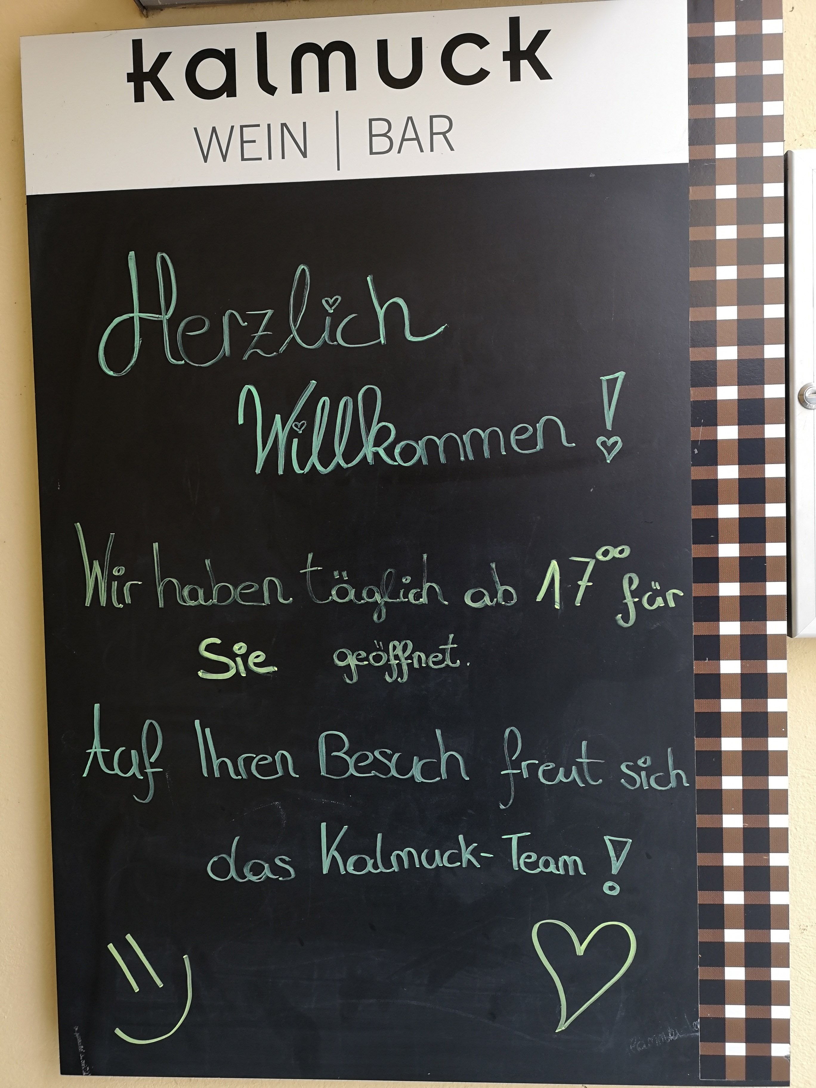 Tábla üdvözlő szöveggel a Kalmuck nevű borozó előtt.