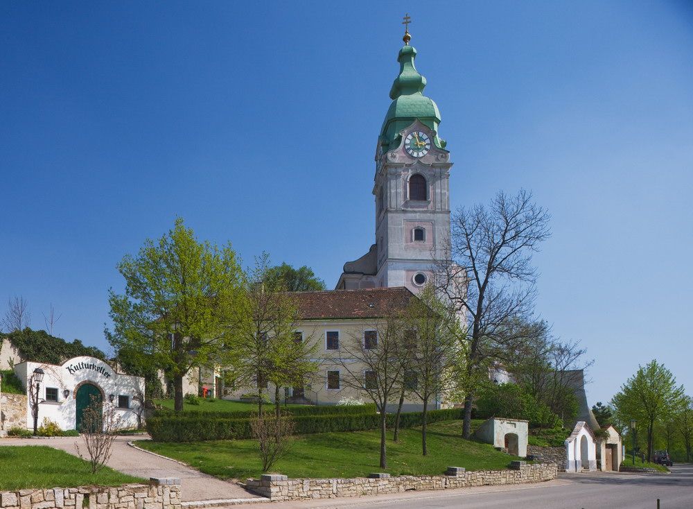 Unterretzbachi templom zöld toronnyal és a környező épületekkel.