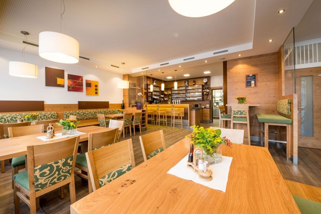 Egy hangulatos, fából készült bútorokkal és bárral berendezett vendéglő belső nézete.