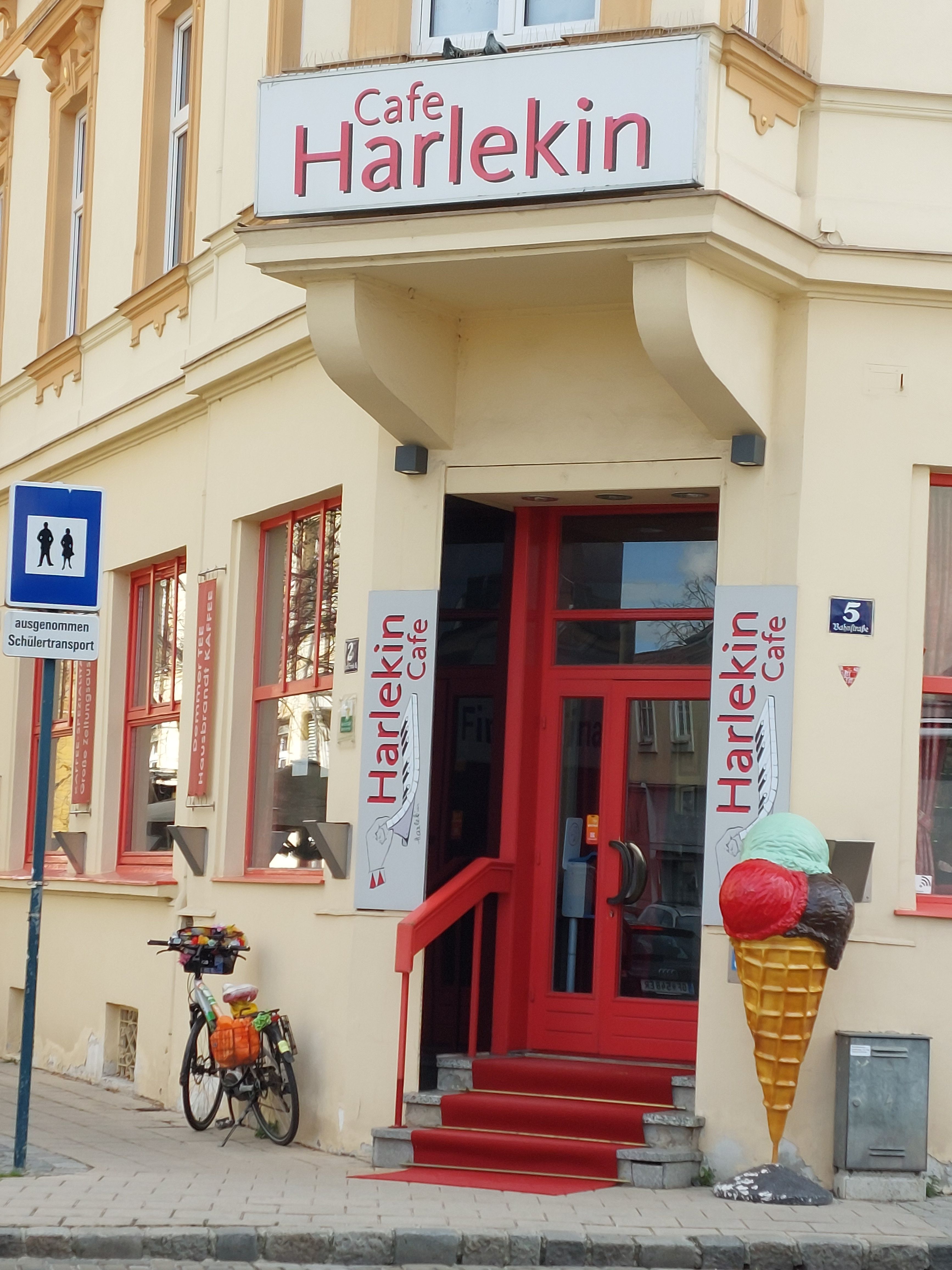 A Cafe Harlekin bejárata piros ajtóval és fagylaltkúp-dísszel.