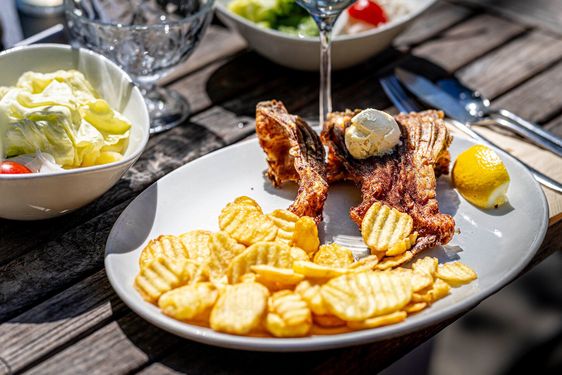 Halétel és burgonyaszeletek fehér tányéron. 