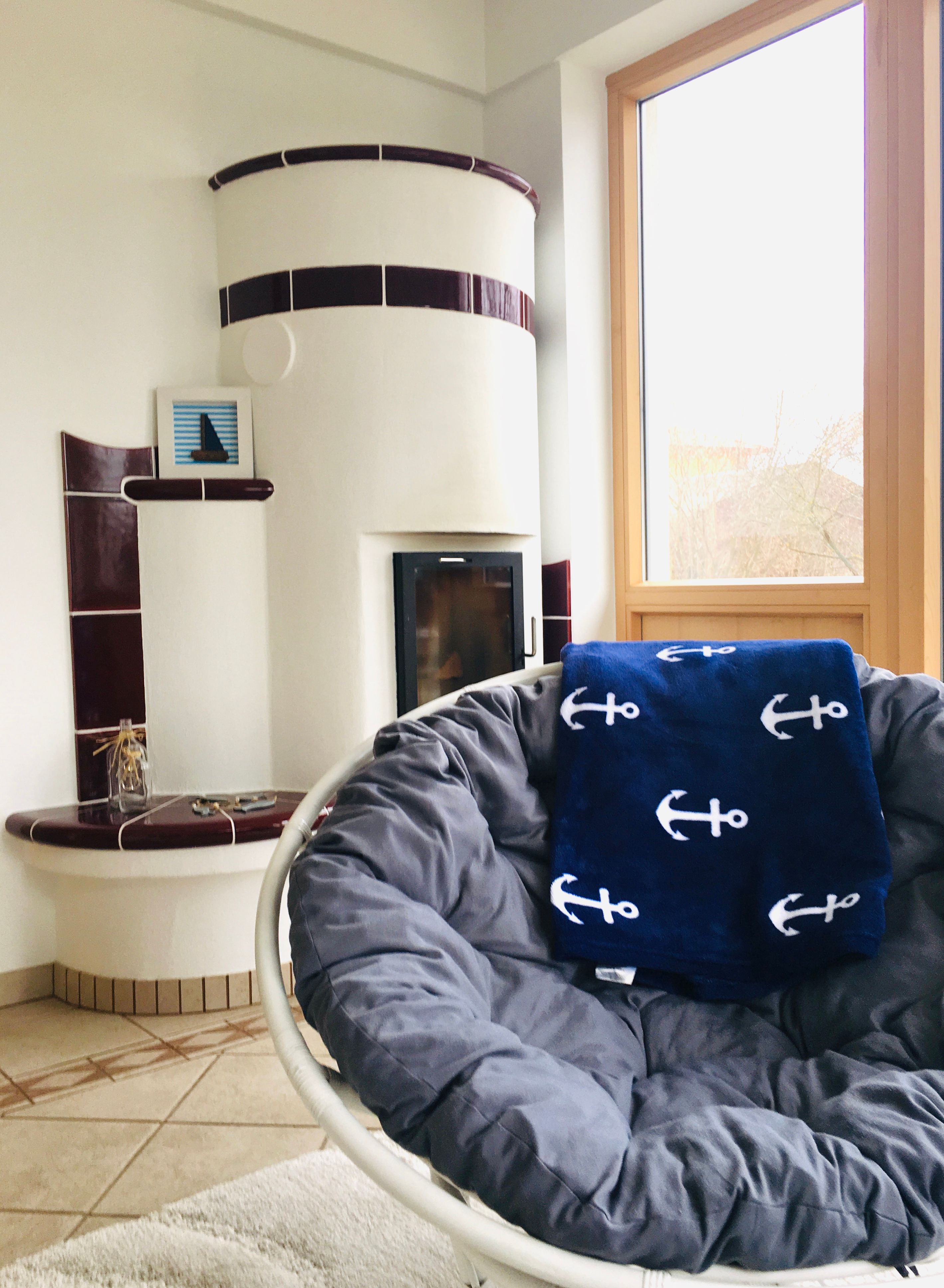 Hangulatos nappali cserépkályhával és fotelekkel.