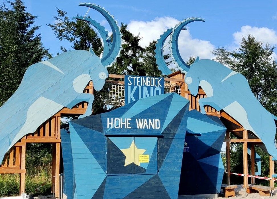 A Steinbock mozi bejárata a Hohe Wand natúrparkban, kék kőszálirányi sziluettekkel.