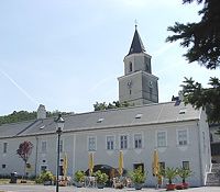 Templom toronnyal és szomszédos épület Szent Andrä-Wördernben.