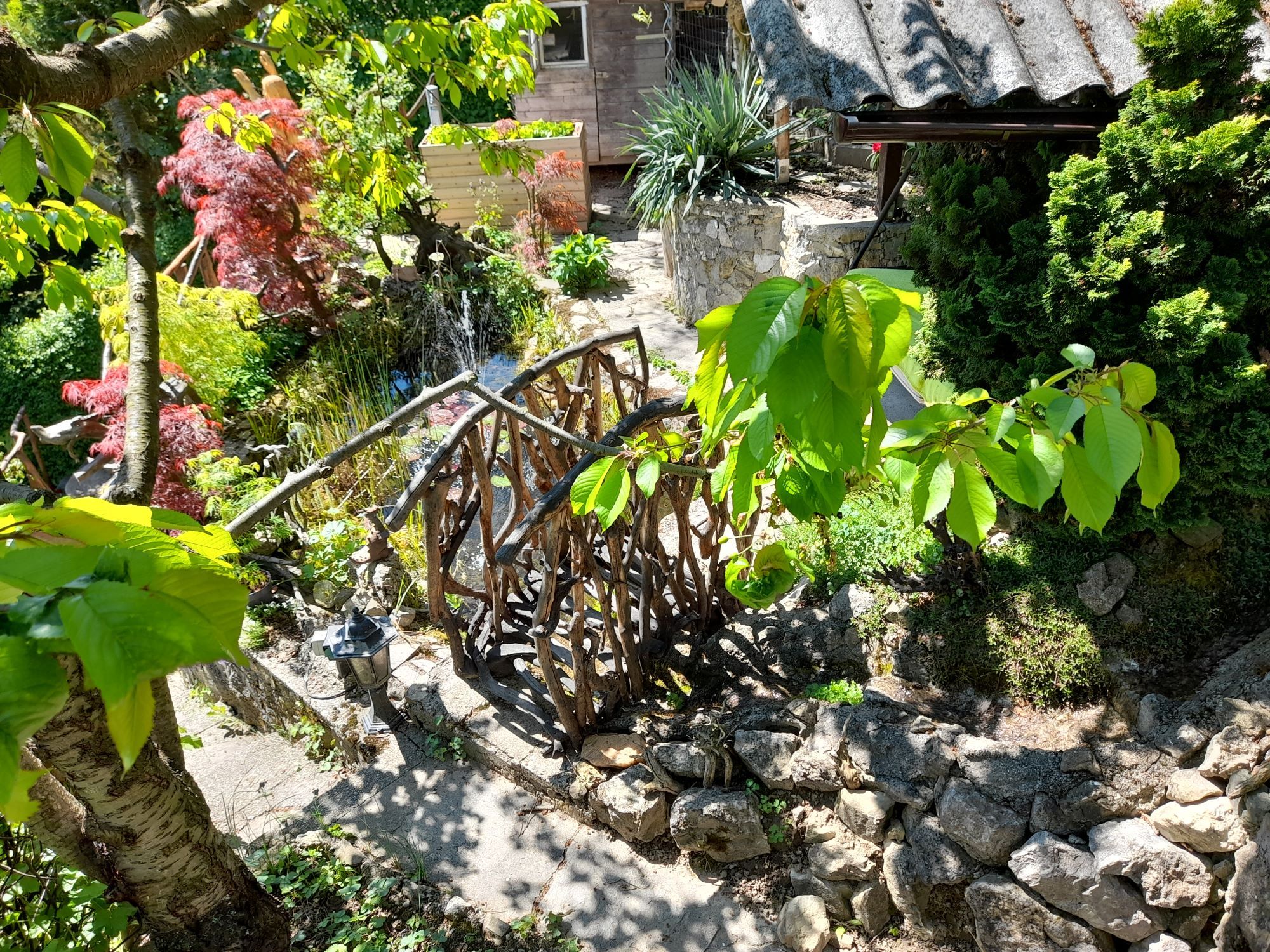 Kert fahíddal, növényekkel és kövekkel.