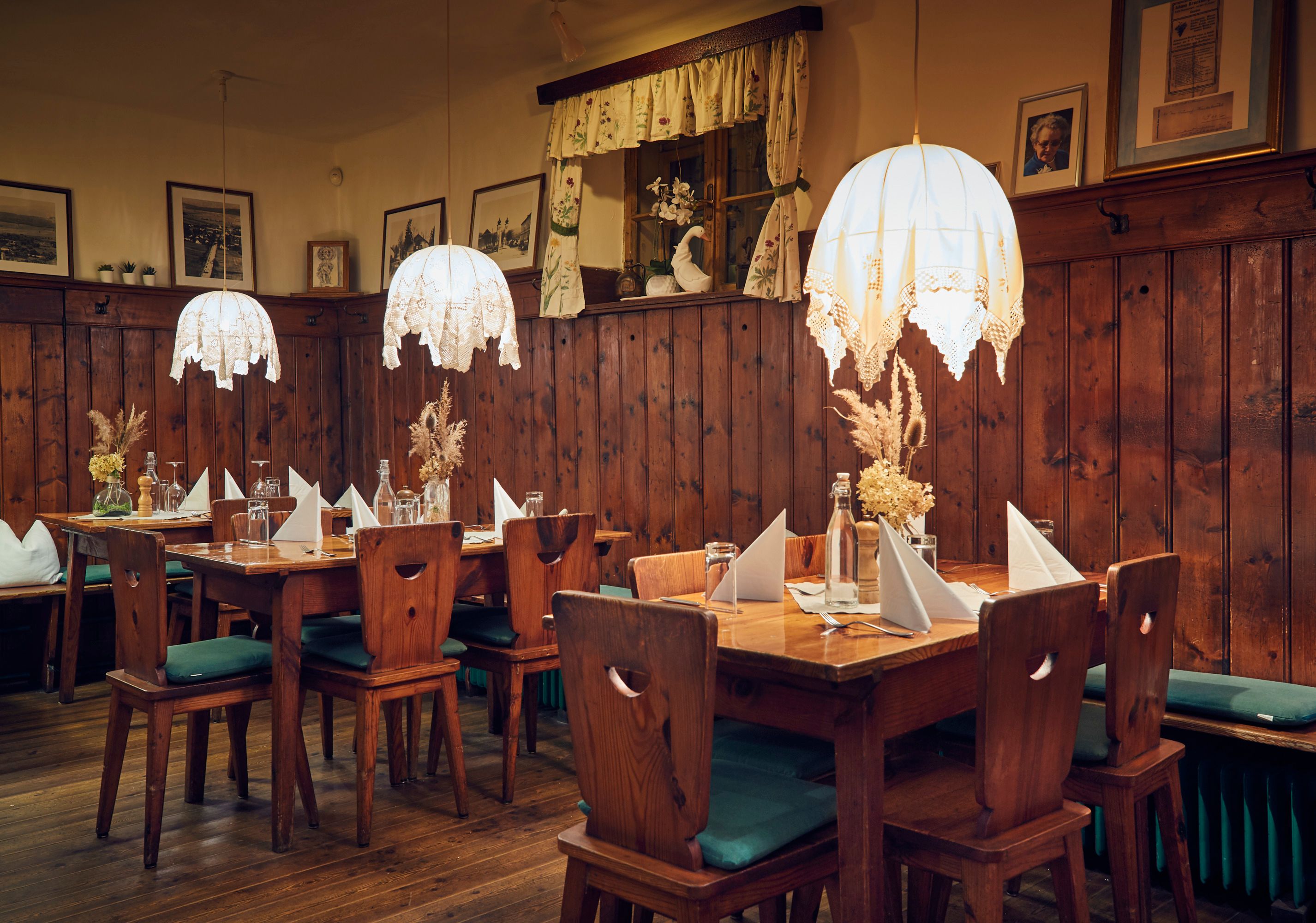 Hangulatos szalon fabútorokkal, asztali díszekkel és függőlámpákkal.