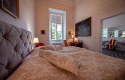 Légi felvétel a Horn-kastélyról, vörös tetővel és óratoronnyal, a háttérben fákkal és várossal.