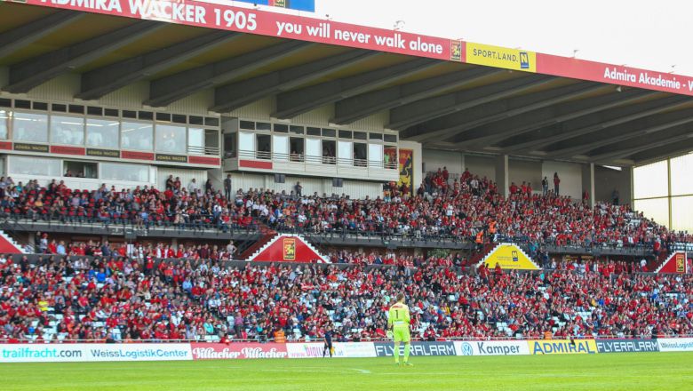 Focistadion teljes lelátóval és egy játékossal a pályán.
