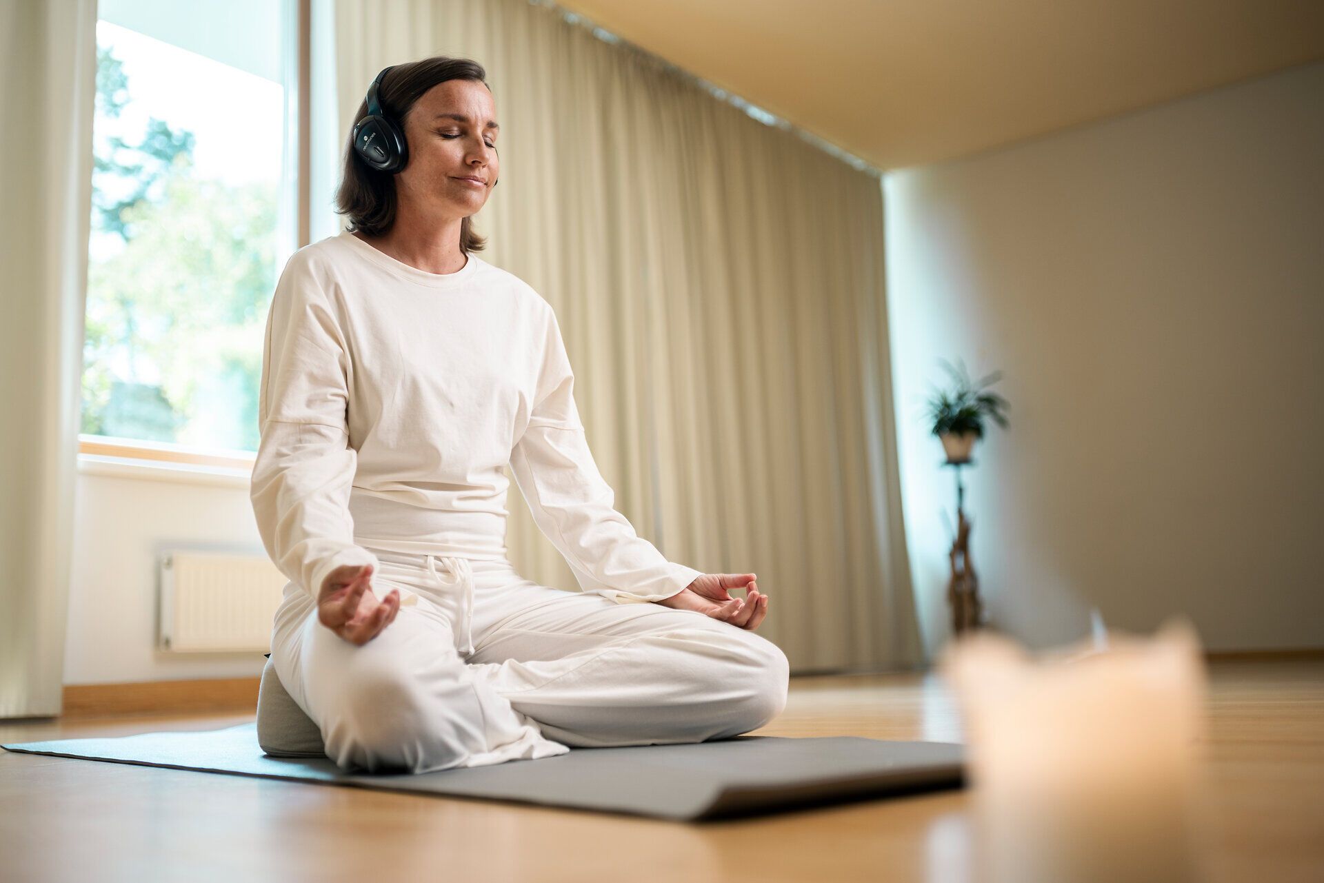 Egy nő fejhallgatóval meditál a Klosterberg egészségügyi szállodában a Waldviertel régióban.