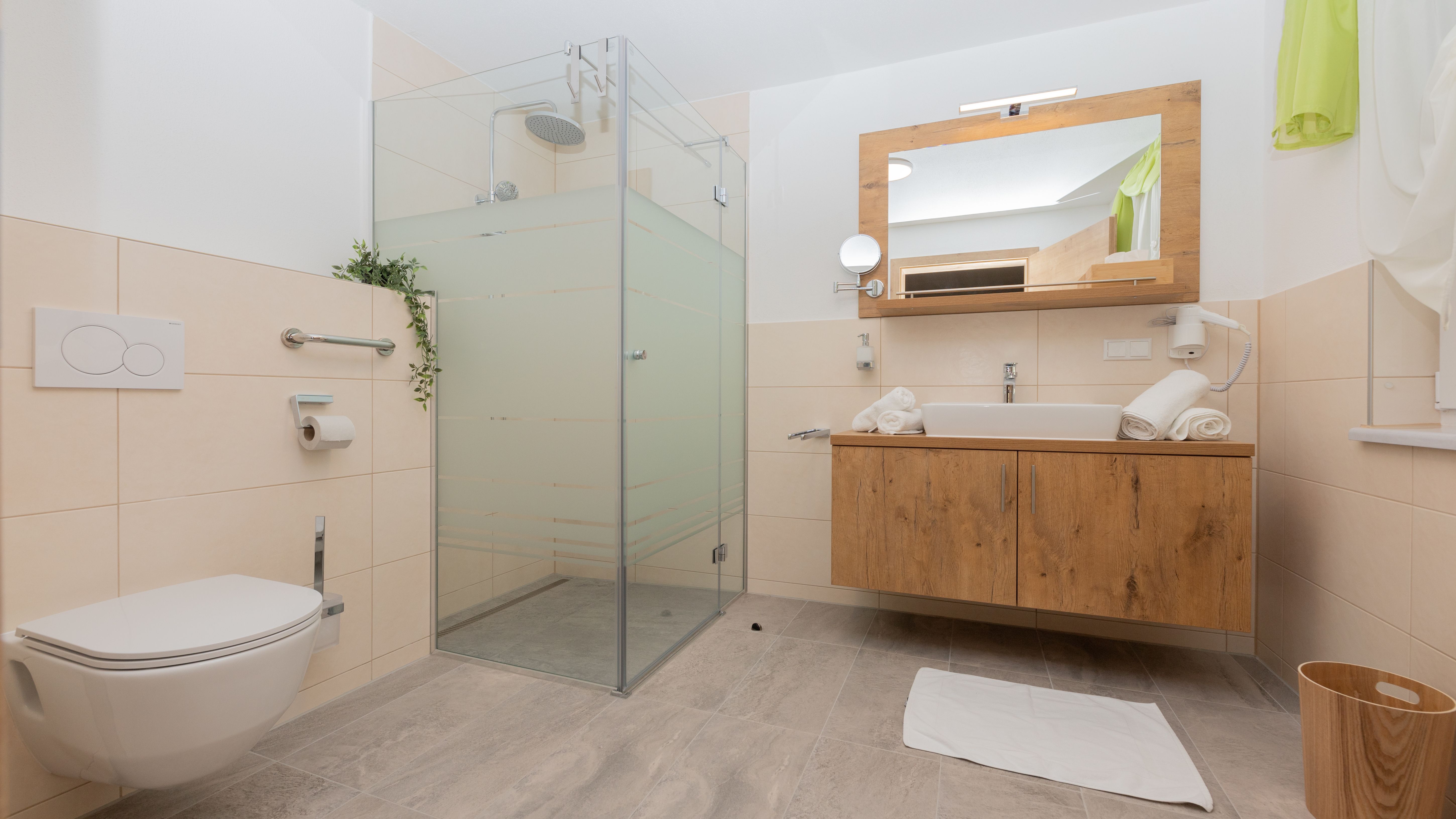 Modern fürdőszoba zuhanyzóval, mosdóval és WC-vel.