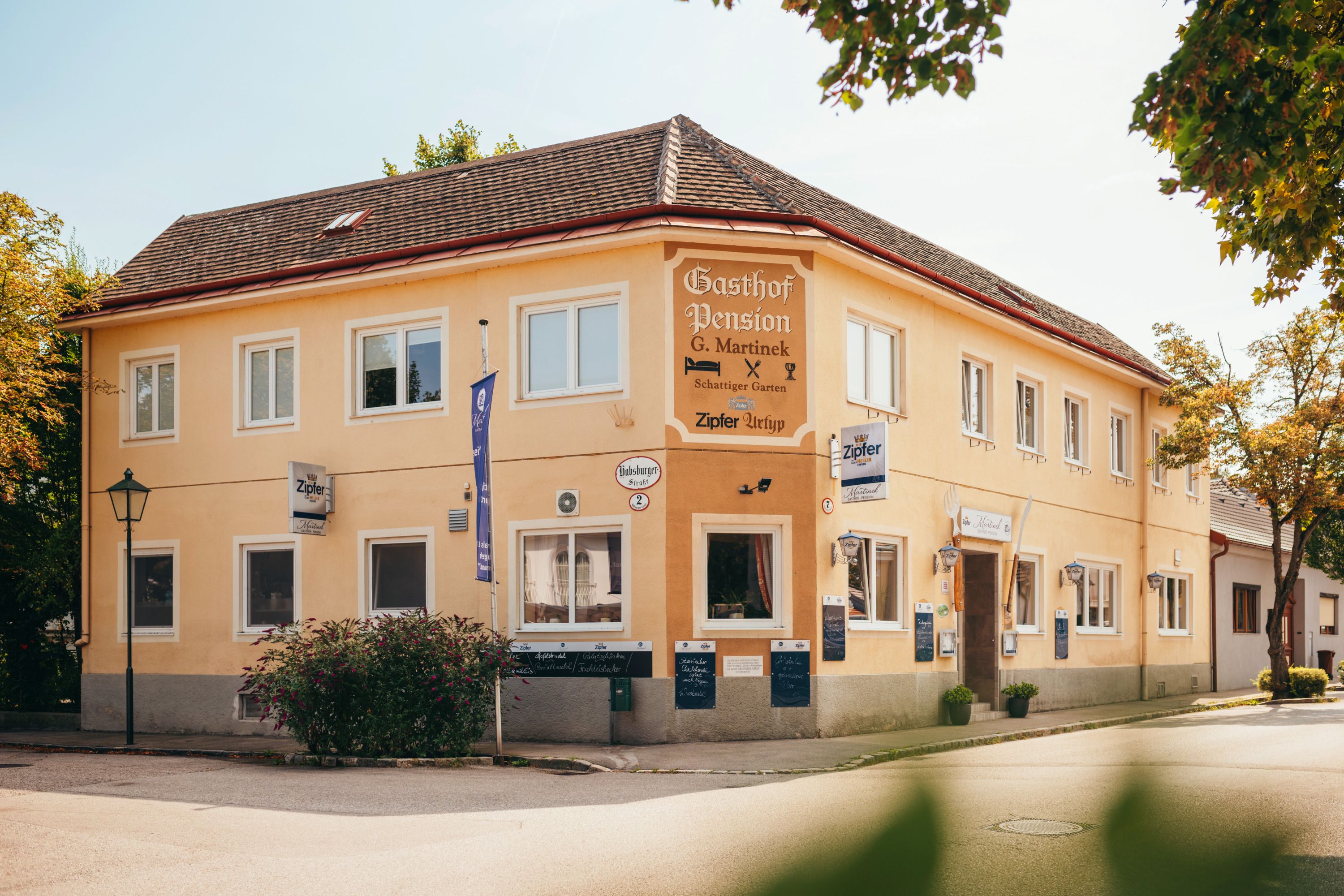 Sárga színű, kétszintes épület "Gasthof Pension G. Martinek" felirattal.
