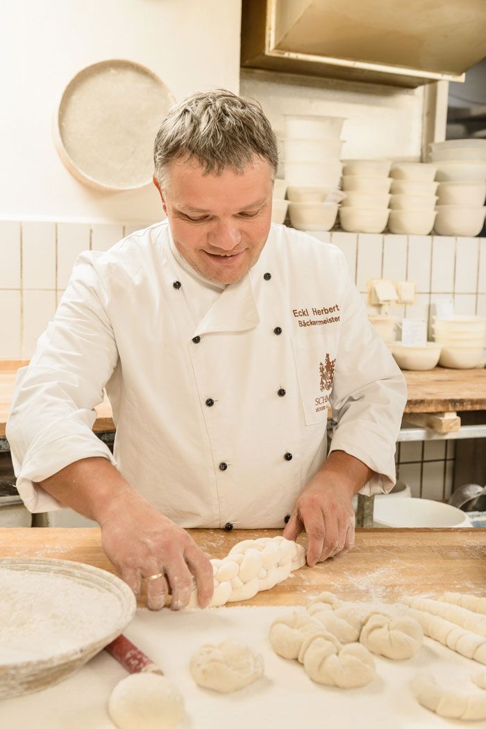 Egy pékmester tésztát formáz egy pékségben.