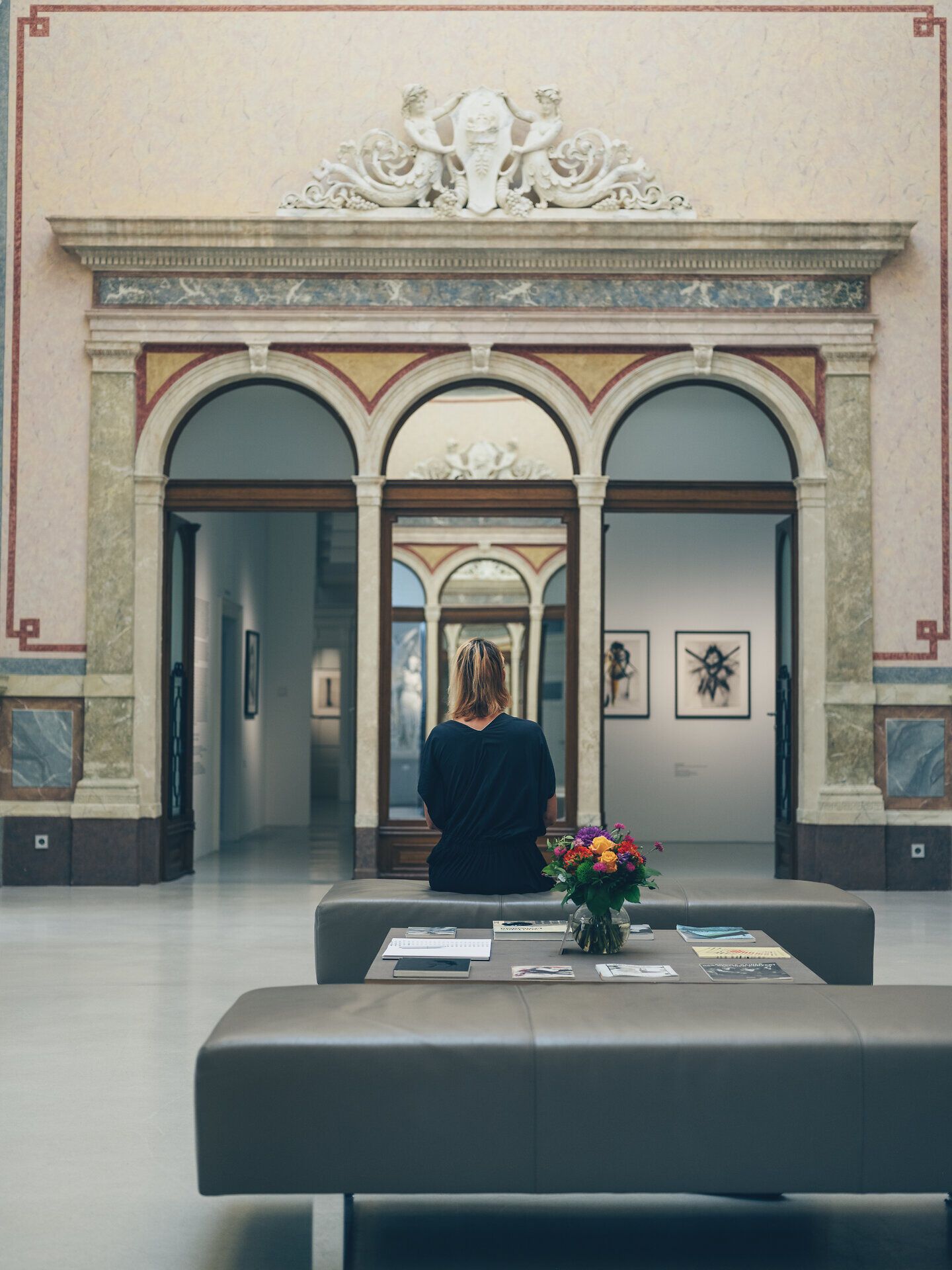 In einem beeindruckenden Museum, umgeben von kunstvoller Architektur, verweilt eine Besucherin in stiller Betrachtung. Die harmonische Verbindung von Kunst und Natur schafft eine inspirierende Atmosphäre, die zum Verweilen einlädt.