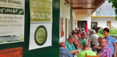 Az emberek egy hosszú asztalnál ülnek egy étterem fedett szabadtéri részén.