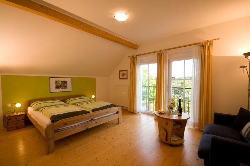 Hangulatos hálószoba franciaággyal, fabútorokkal és erkélykapcsolattal.