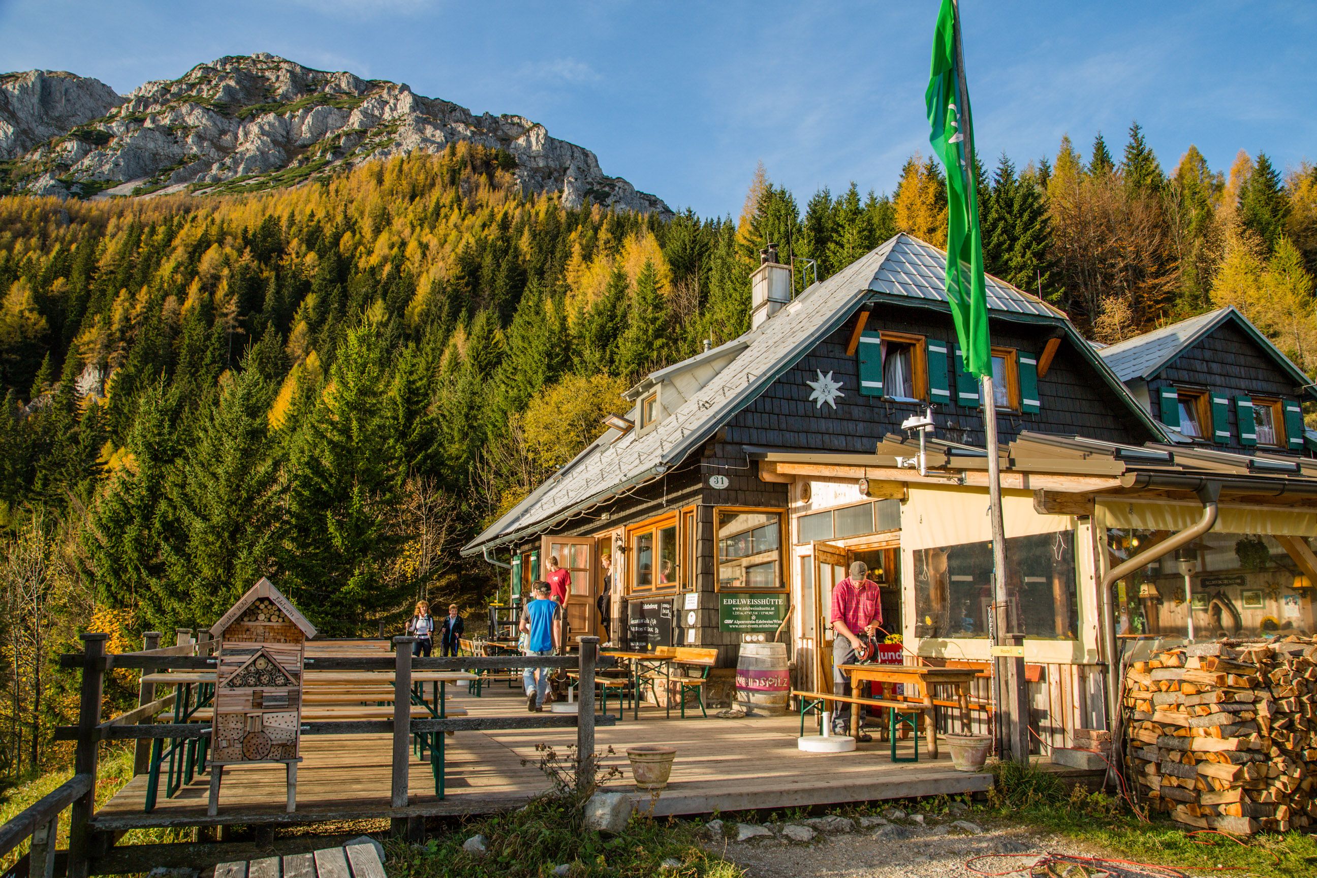 Edelweiss kunyhó a Schneeberg-hegyen, a háttérben hegyi táj és erdő.