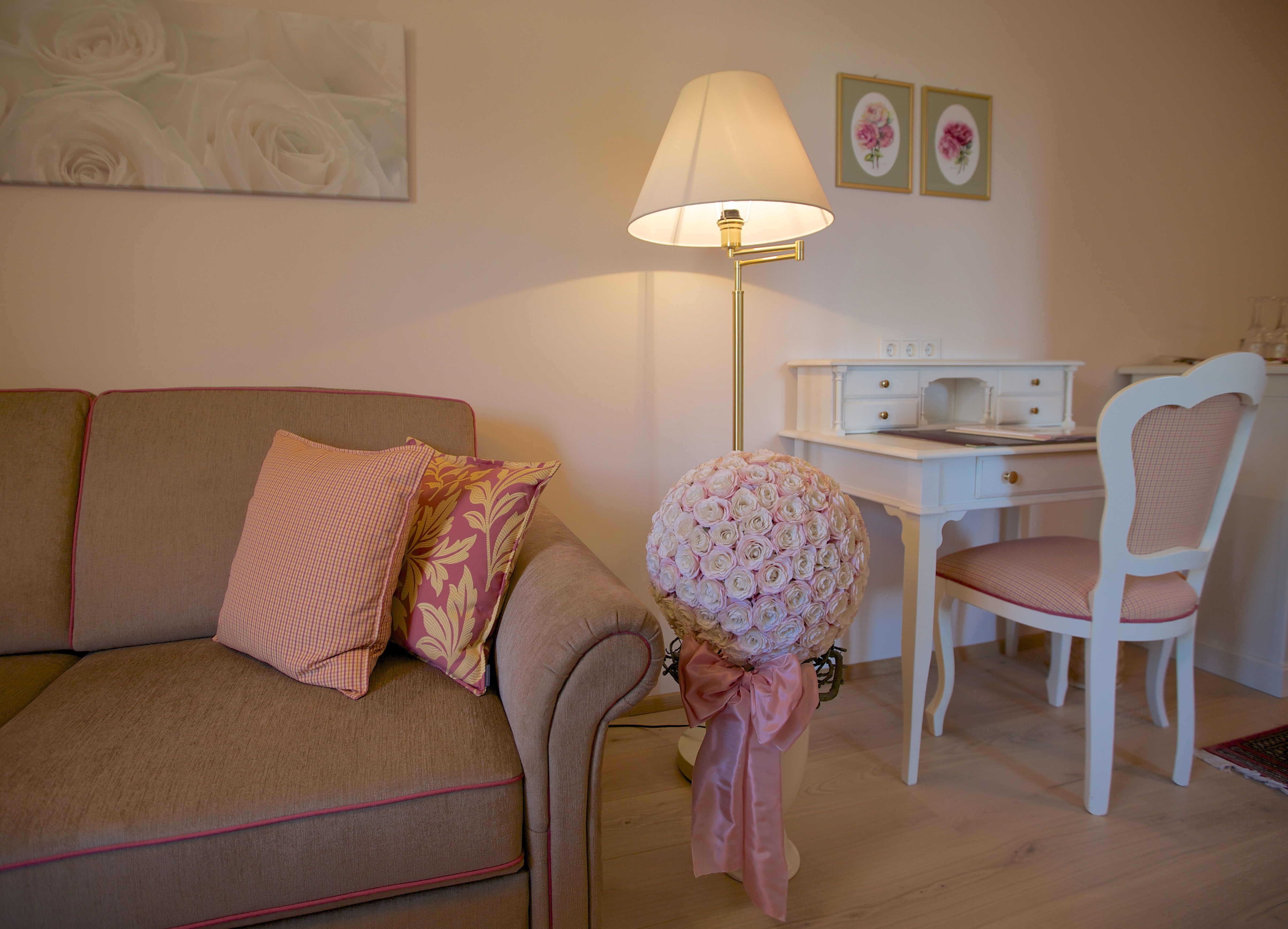 Hangulatos nappali kanapéval, íróasztallal és virágokkal.