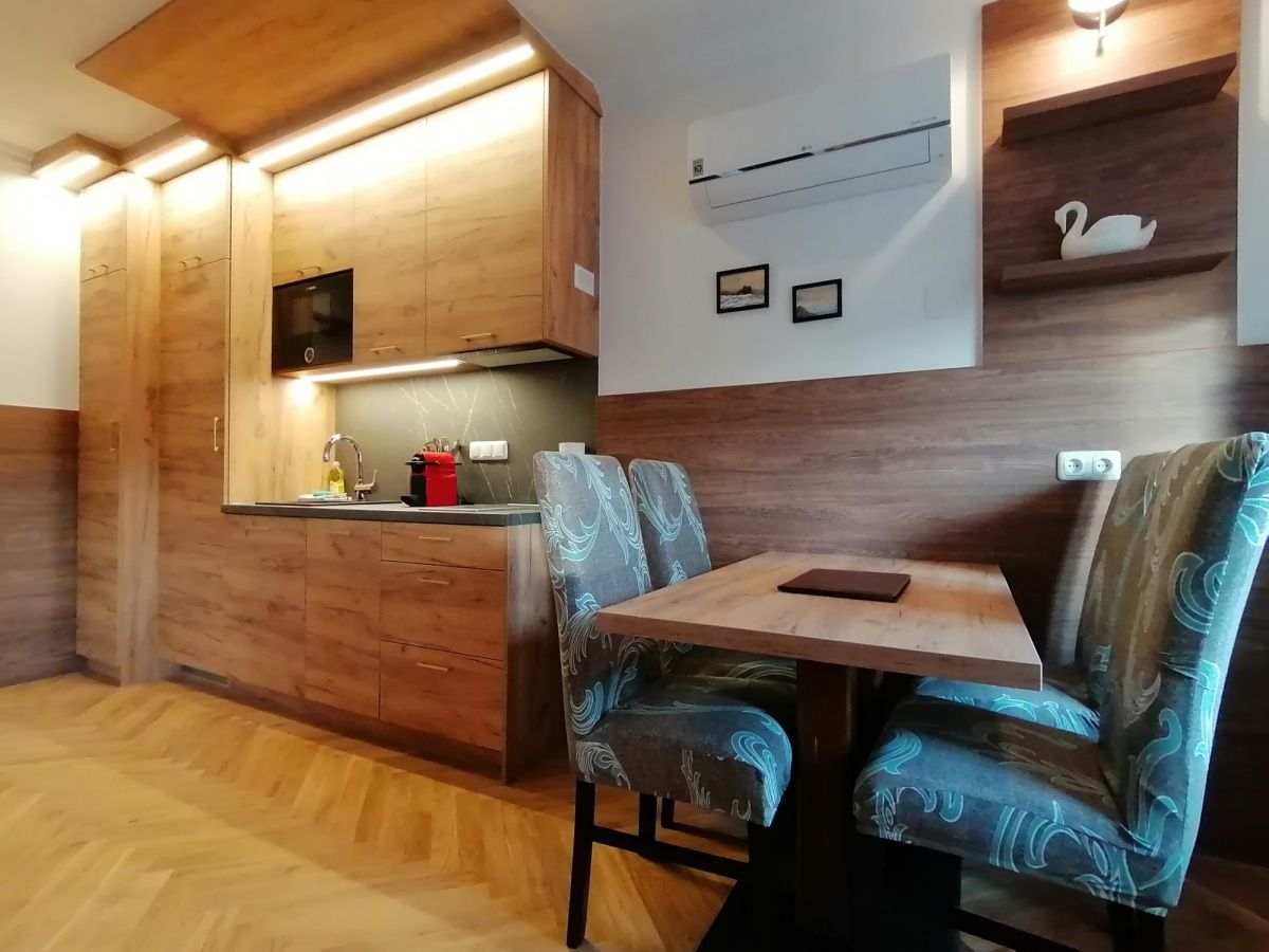 Modern konyha fa bútorokkal és étkezőasztallal egy lakásban.