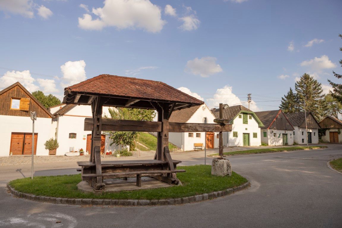 Történelmi borprés Kettlasbrunnban a hagyományos pincesoron álló házak előtt.