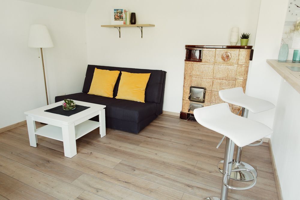 Modern nappali kanapéval, dohányzóasztallal, bárszékekkel és kandallóval.