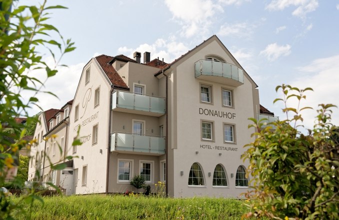 A Hotel Restaurant Donauhof k&uuml;lső n&eacute;zete az erk&eacute;lyekkel &eacute;s a kerttel.