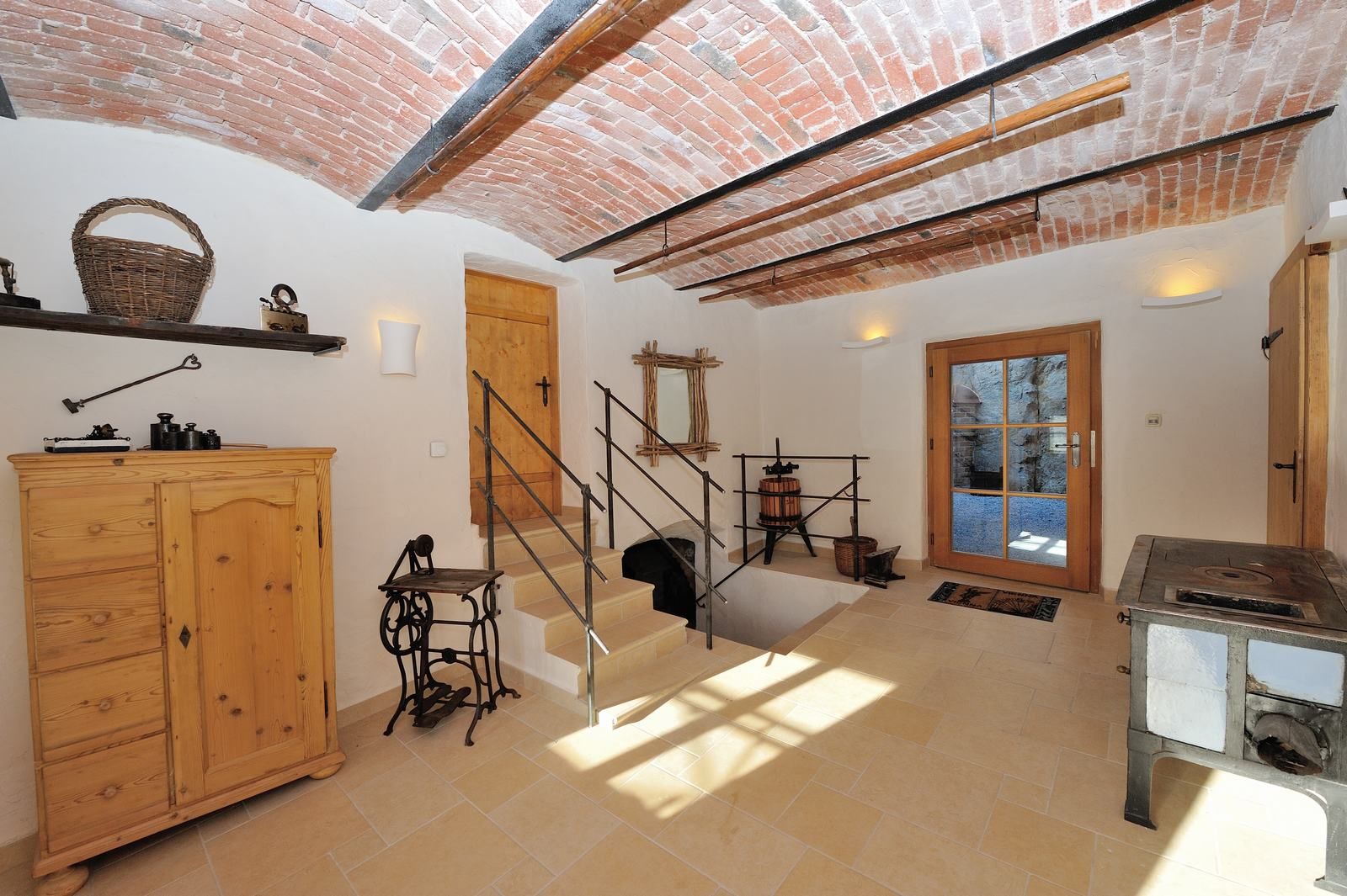 Belső tér boltíves mennyezettel, fabútorokkal és antik tárgyakkal.