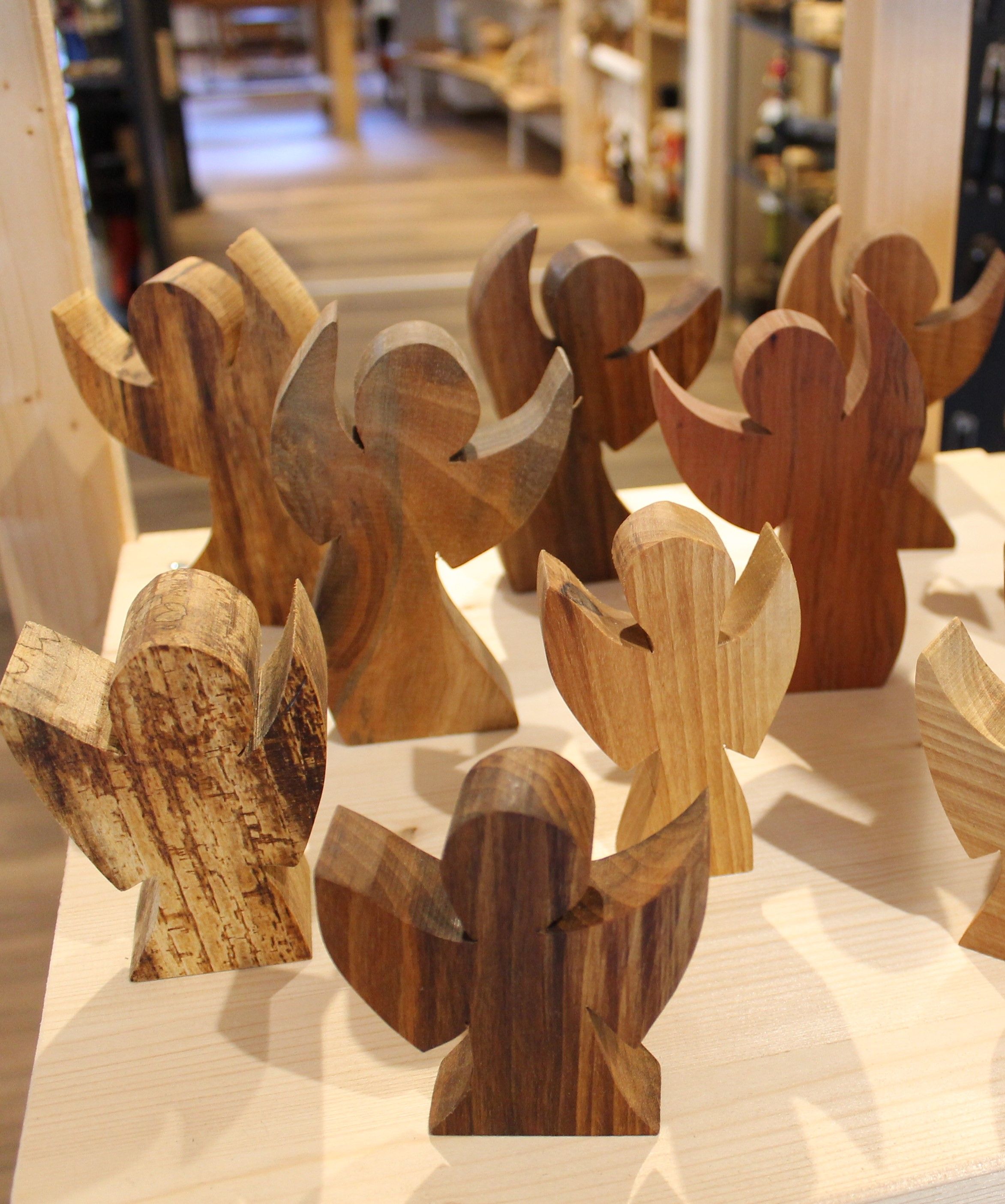 Fából készült angyal egy boltban lévő asztalon.