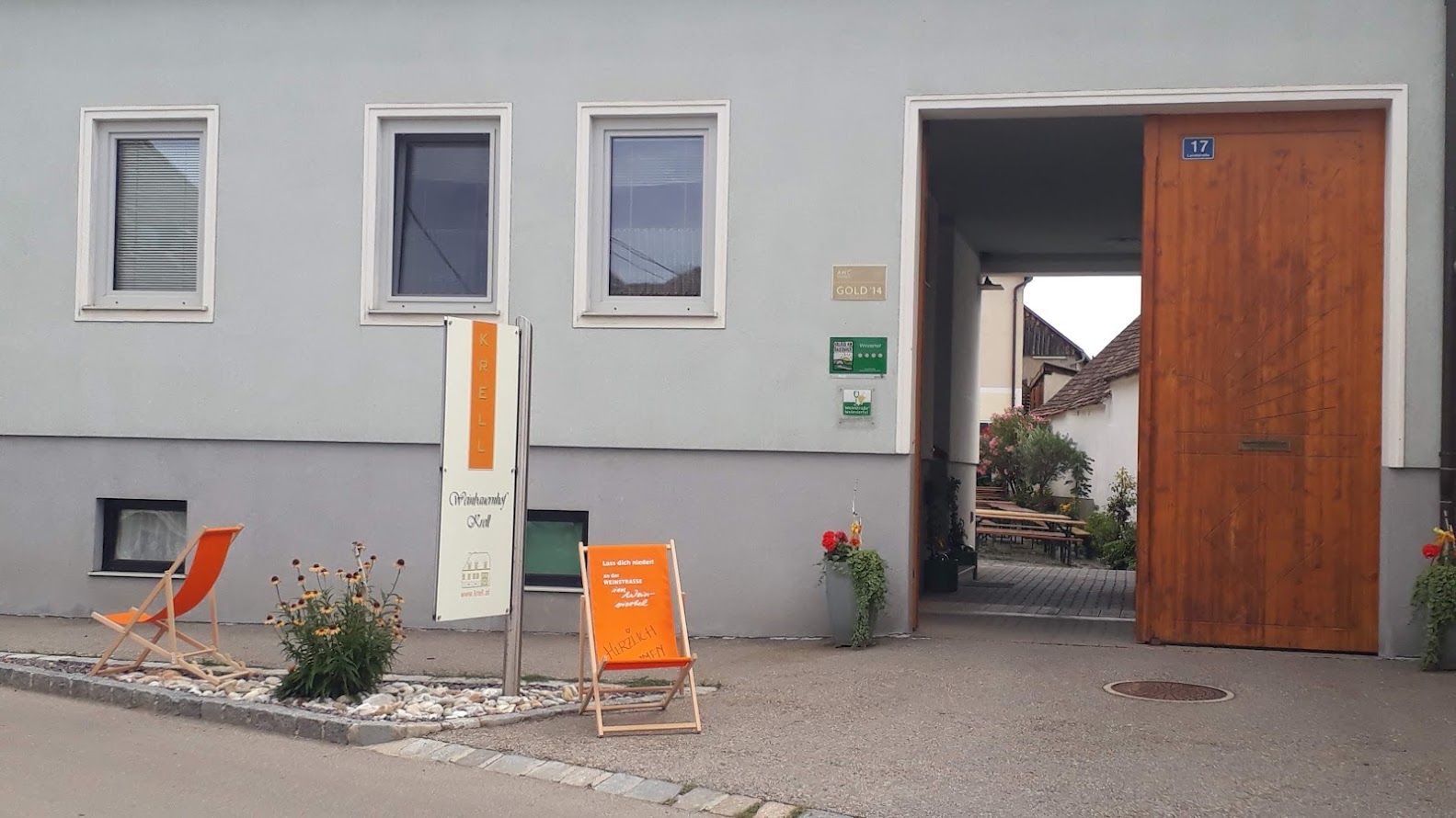 Egy borászat bejárata "Krell" felirattal, nyugágyakkal és növényekkel.