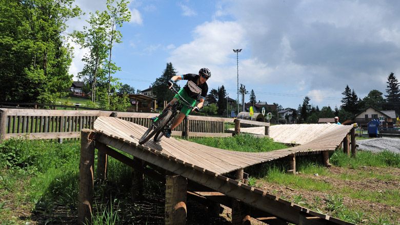 Gyermek lovagol egy fából készült rámpán a Bikepark Semmeringben.
