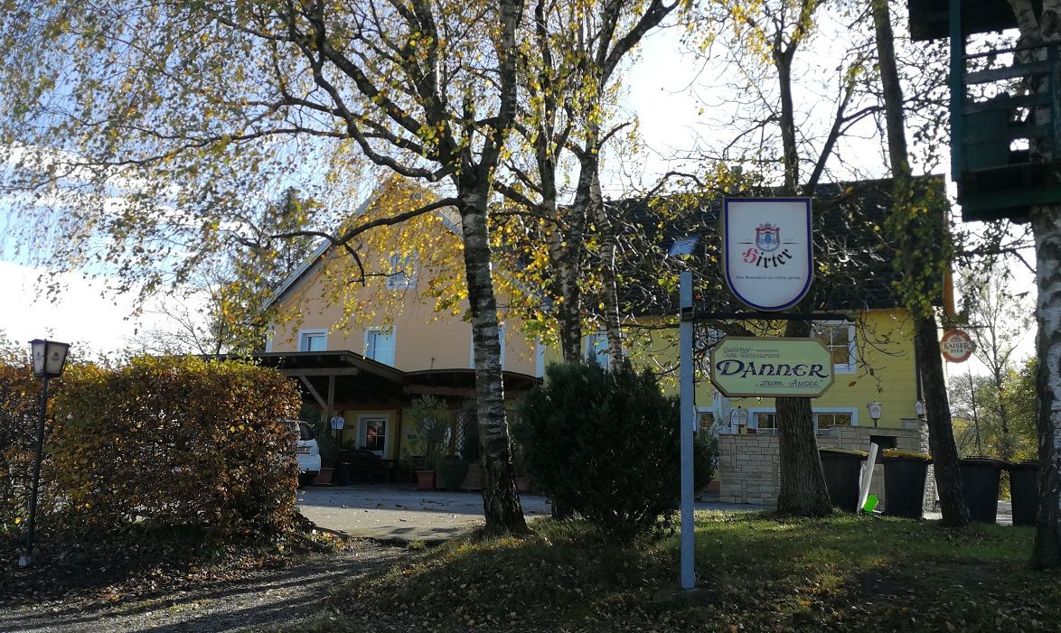 Gasthaus Danner, előtérben fákkal és egy táblával.