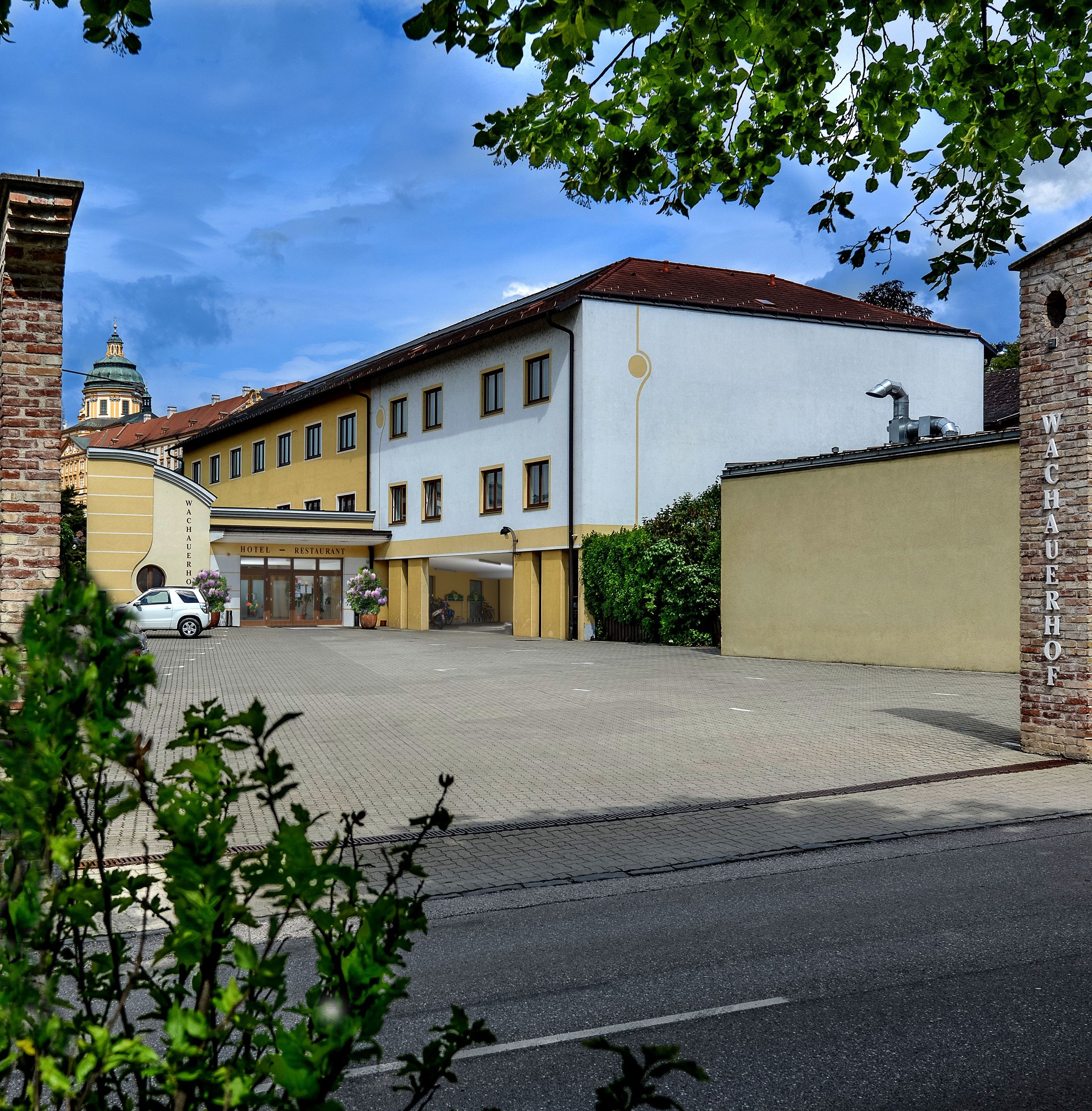 A melki Wachauerhof külső nézete a parkolóval és az épület homlokzatával.
