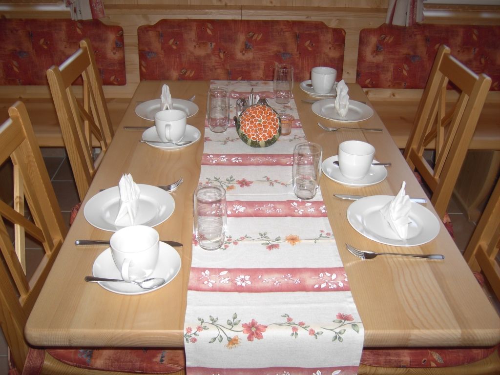 Terített asztal a reggelizőhelyiségben, edényekkel és poharakkal.
