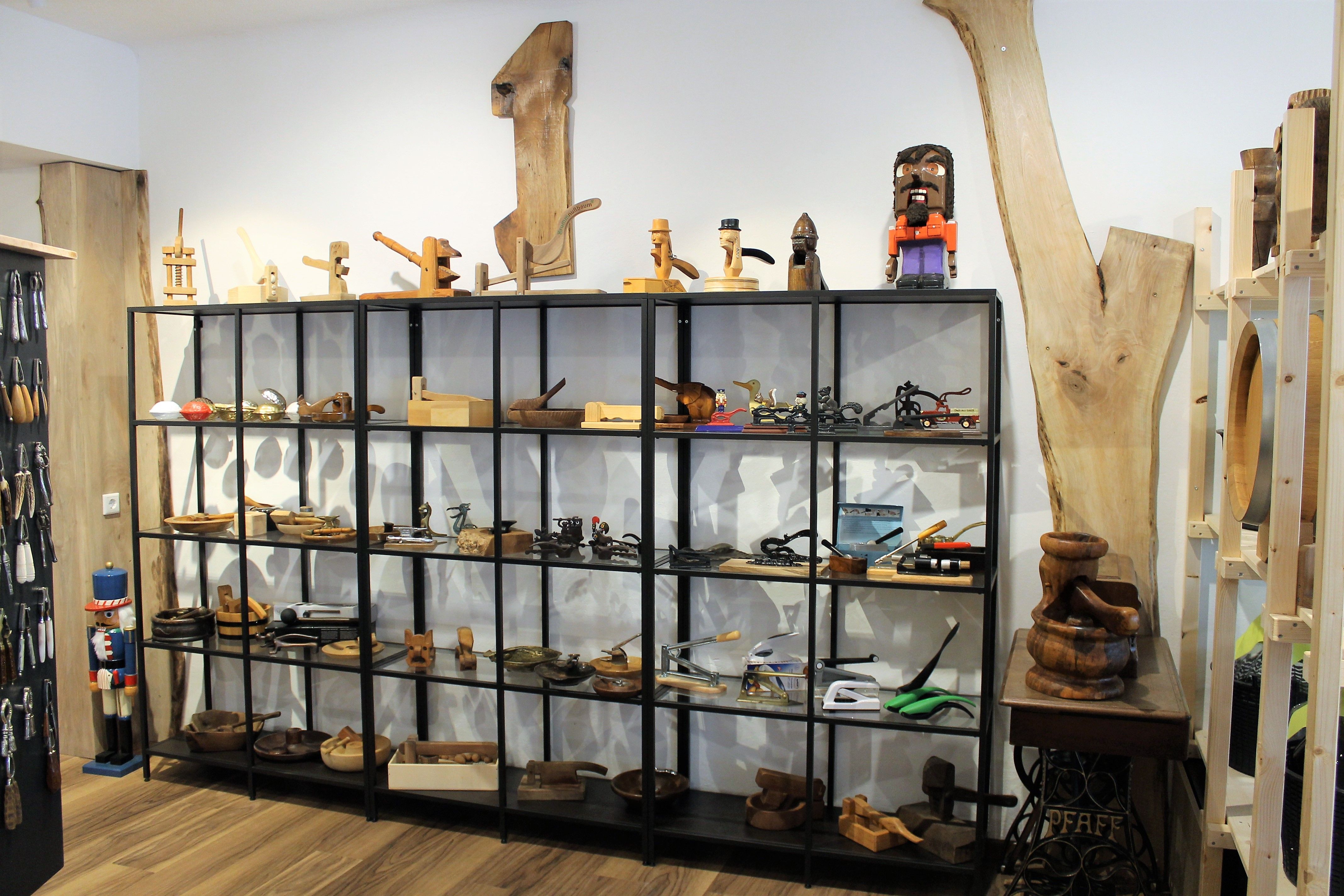 Fából készült tárgyakat és szerszámokat tartalmazó polc egy bemutatóteremben.