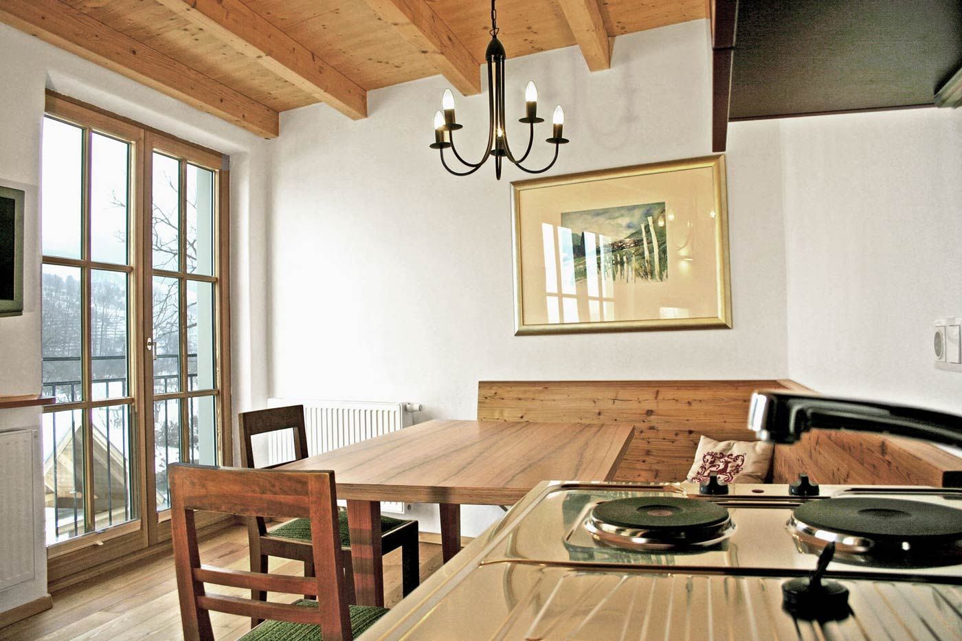 Hangulatos vendégszoba fabútorokkal és konyhasarokkal.