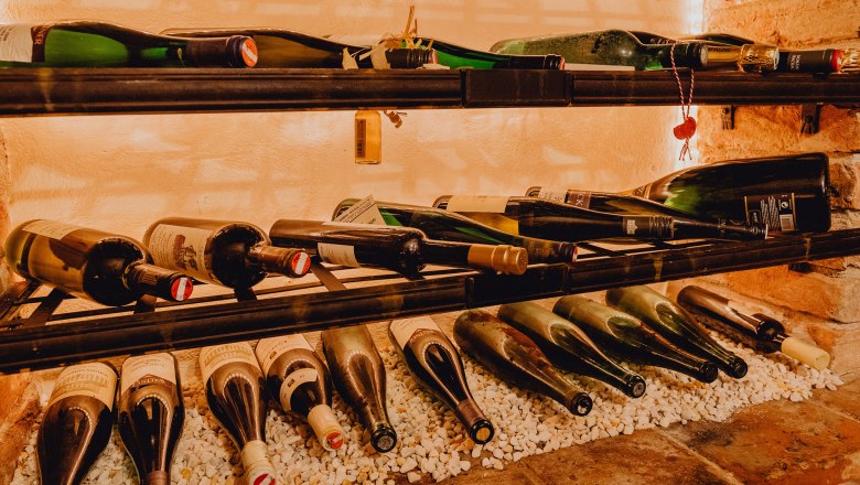 Borosüvegek egy polcon fehér köveken.