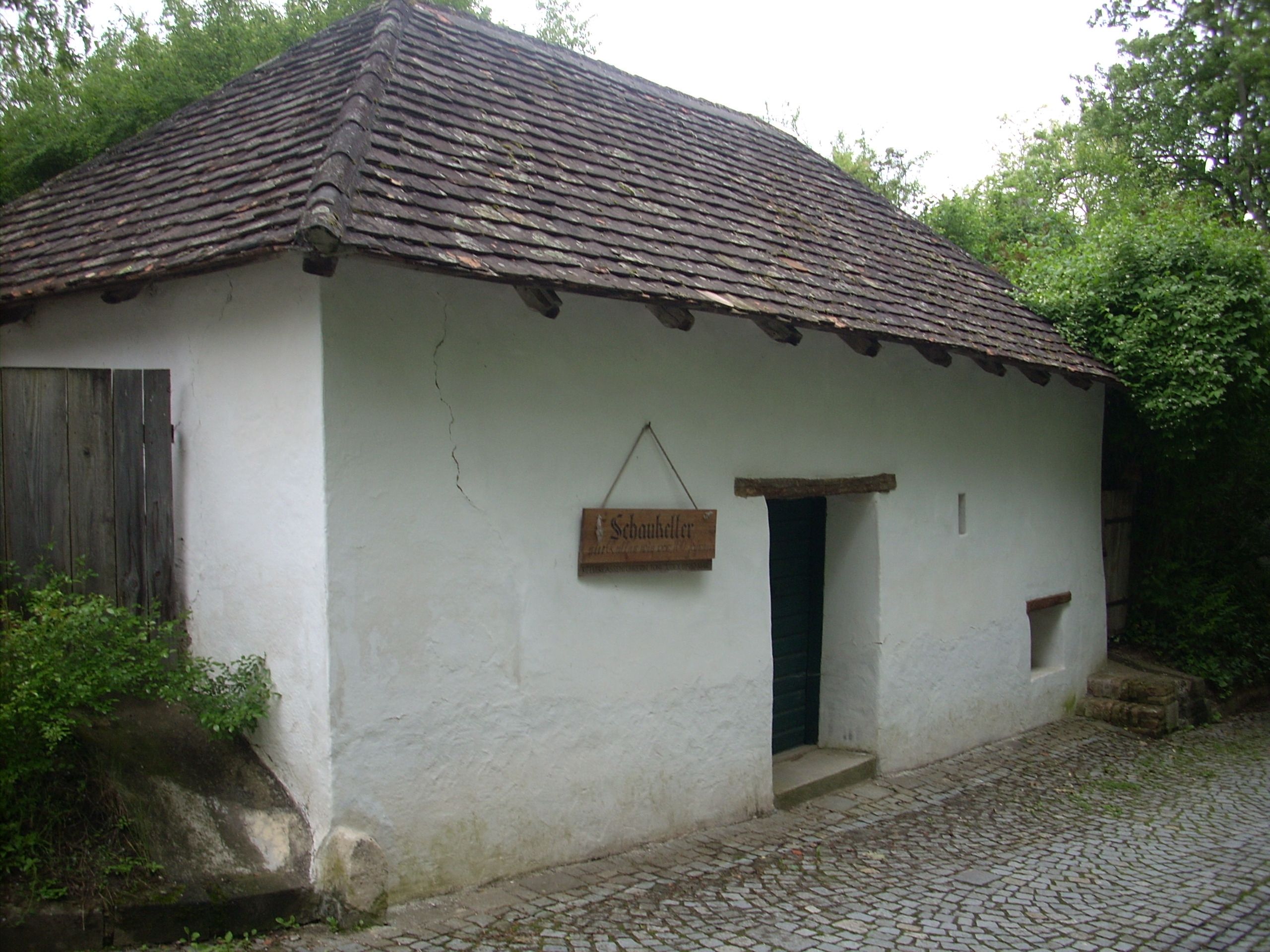 Hagyományos épület fehér homlokzattal és cseréptetővel, "Schaukeller" felirattal.