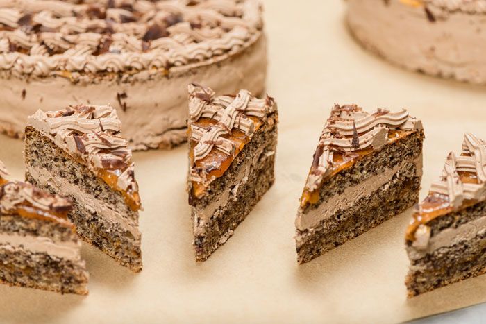 Közelkép szeletelt csokoládétortadarabokról, krémmel és csokoládémázzal.